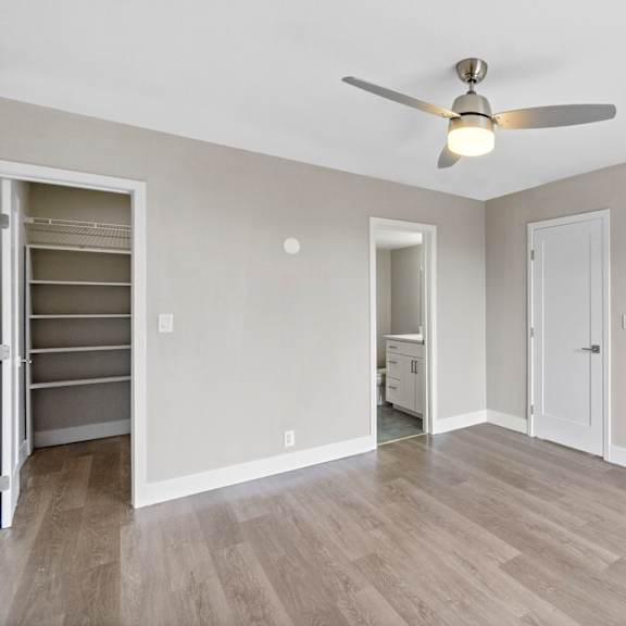 a room with a ceiling fan and light fixture, and a closet with shelves.at ocean edge @ laguna beach, laguna beach california