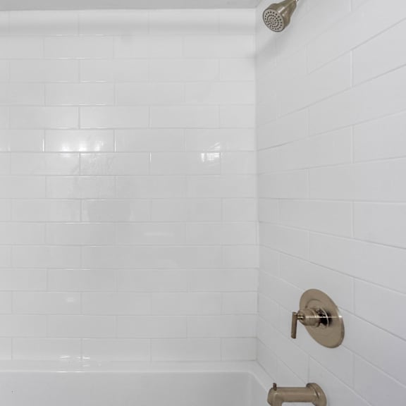 a white tiled shower with a shower head and faucet.at ocean edge @ laguna beach, california