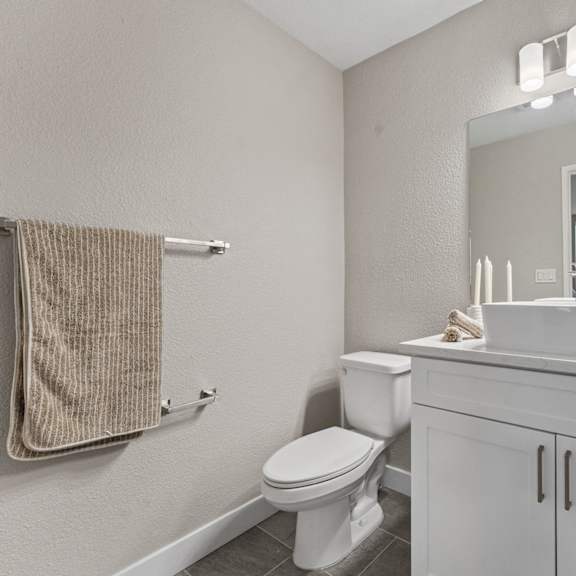 a white bathroom with a toilet, sink, and mirror at tamarack sands apartment homes, california, 92008