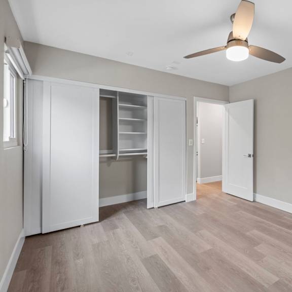 a room with a ceiling fan and a wooden floor.