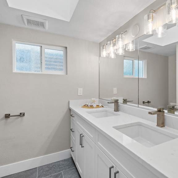a bathroom with a large mirror and a window.