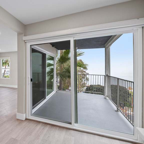 a room with a sliding glass door leading to a balcony.