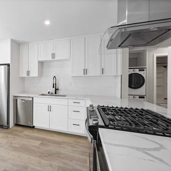 a renovated kitchen with white cabinets and stainless steel appliance at ocean breeze terrace apartment, huntington beach, ca, 92648