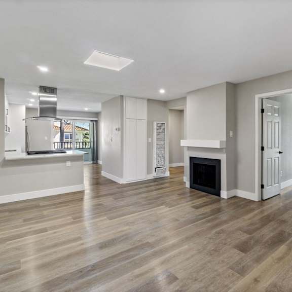 a renovated living room with a fireplace and a kitchen at ocean breeze terrace apartment, california