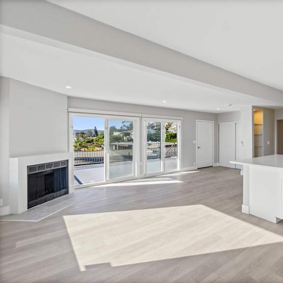 a modern kitchen with a fireplace and a view of the outdoors.at ocean edge @ laguna beach, laguna beach