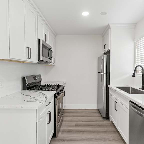a kitchen with white cabinets and stainless steel appliances at seaview terrace apartment homes, san clemente, ca