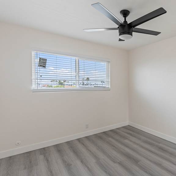 a bedroom with a ceiling fan and a window at seaview terrace apartment homes, san clemente, california