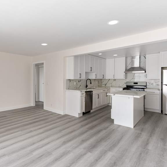 a bedroom with a medium sized bed and a kitchen with a stove and a sink at seaview terrace apartment homes, san clemente, 92672