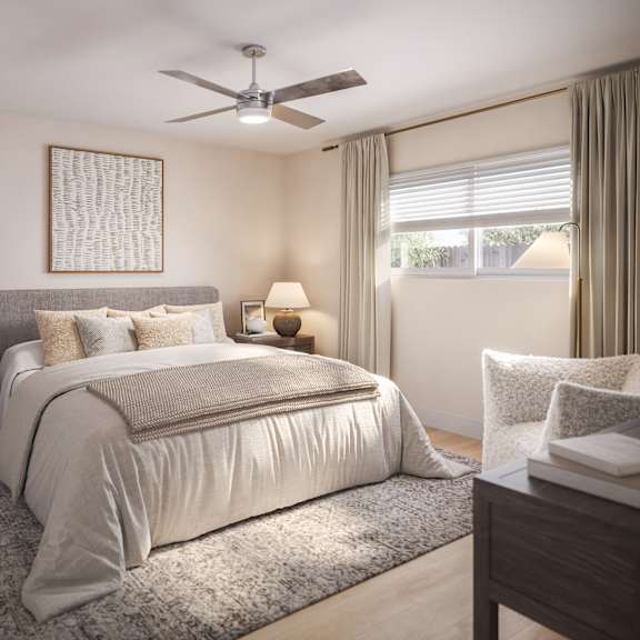 a bedroom with a large bed, a ceiling fan, and a nightstand with a plant on it.