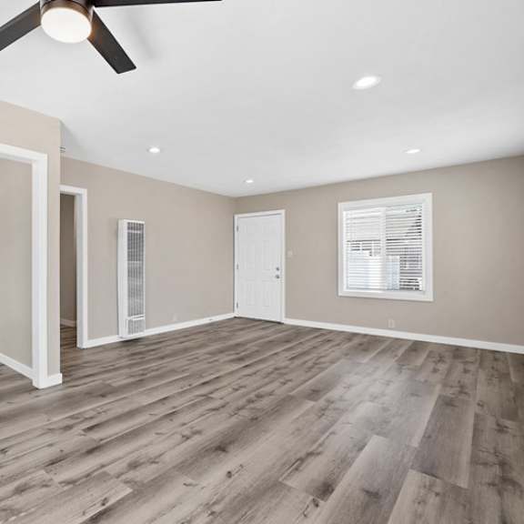 an empty living room with a ceiling fan at huntington manor homes apartment, huntington beach, ca