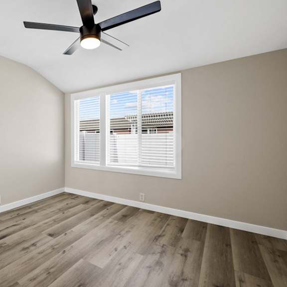 an empty bedroom with a ceiling fan and window at huntington manor homes apartment, huntington beach, 92648