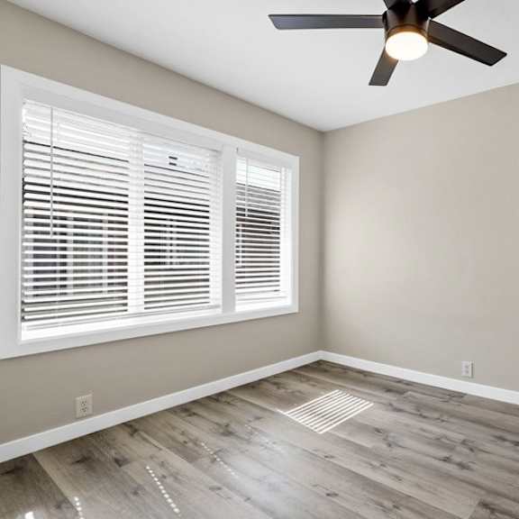 an empty bedroom with a ceiling fan and window at huntington manor homes apartment, huntington beach, ca, 92648