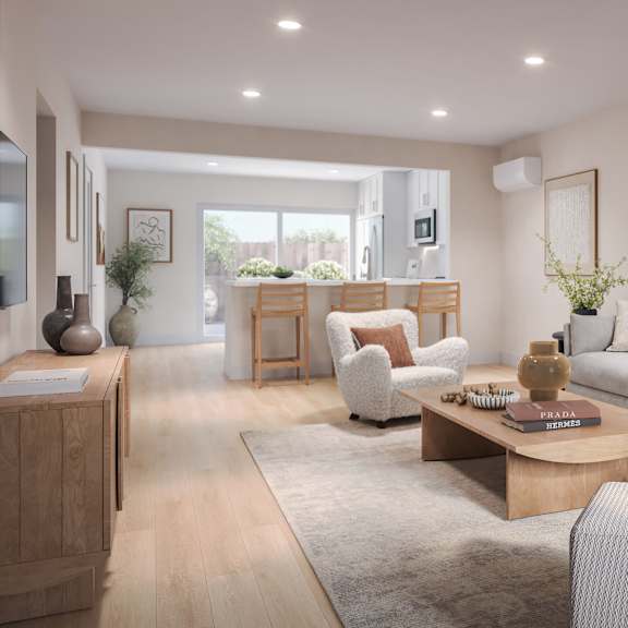 a modern living room with a grey sofa, wooden coffee table, and a large window.