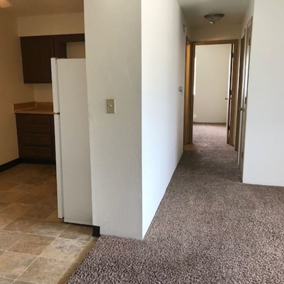 an empty room with a tile floor and white walls