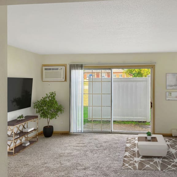 a living room with a sliding glass door leading to a backyard