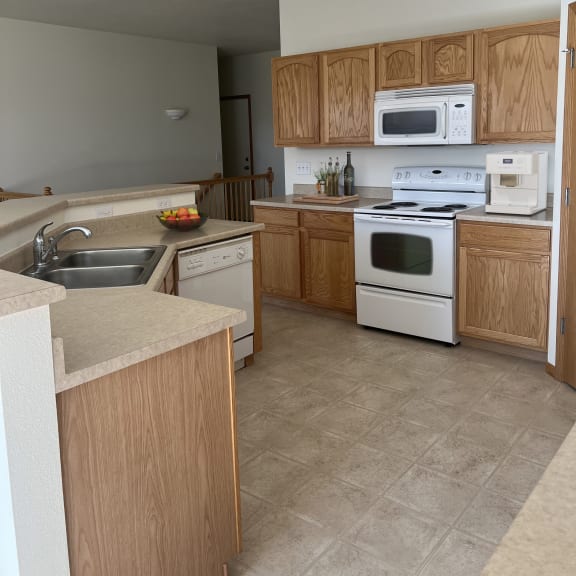 a kitchen with white appliances and wooden cabinets