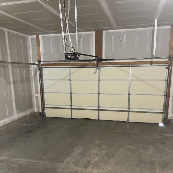 the inside of a garage with white walls and a chain link door