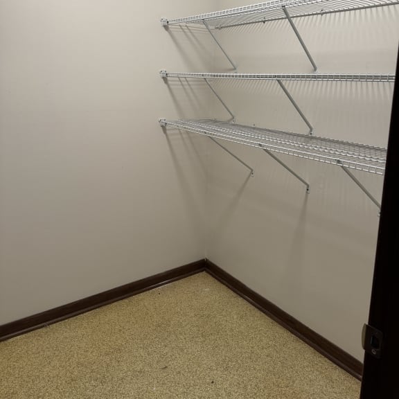 a room with white walls and metal shelves on the floor