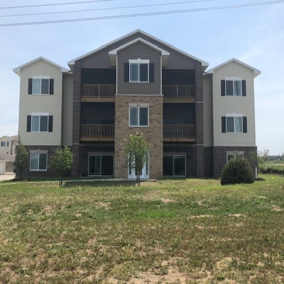 a large apartment building with a grassy area in front of it