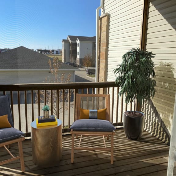 a balcony with two chairs and a table