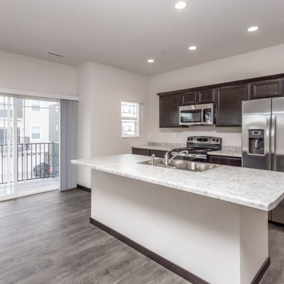 a kitchen with a counter top and a stainless steel refrigerator