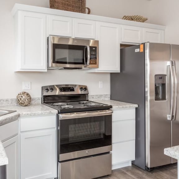 a kitchen with stainless steel appliances and white cabinets