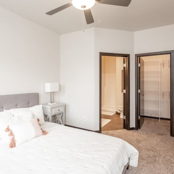a bedroom with a large bed and a ceiling fan