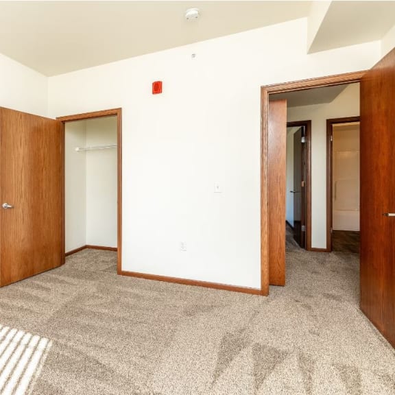 a room with a carpeted floor and two doors