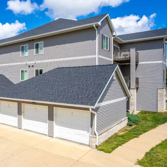 a garage with three garage doors in front of a house