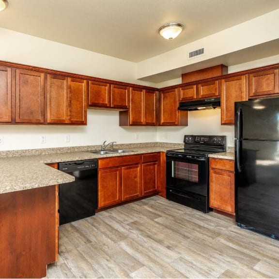 a kitchen with black appliances and wooden cabinets