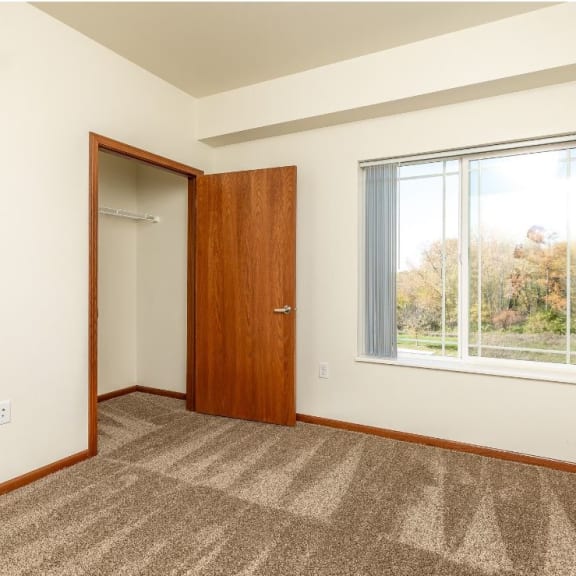 a room with a window and a door and a closet