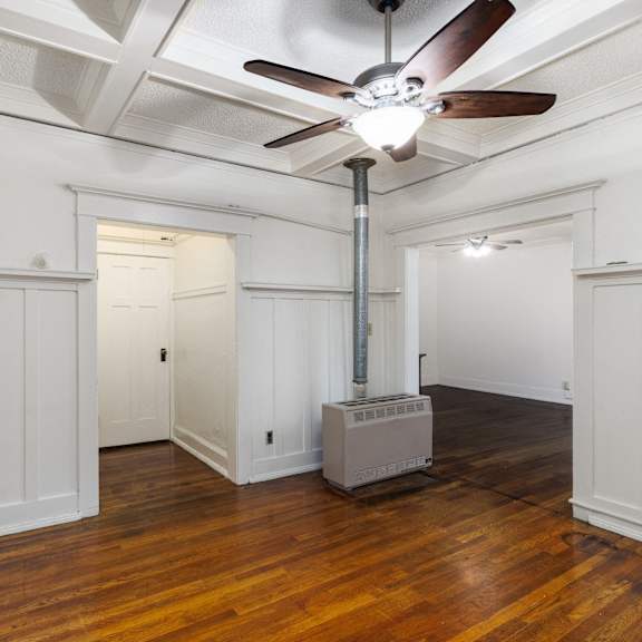 a room with a ceiling fan and a wood floor at midtown apartments, portland, 97209