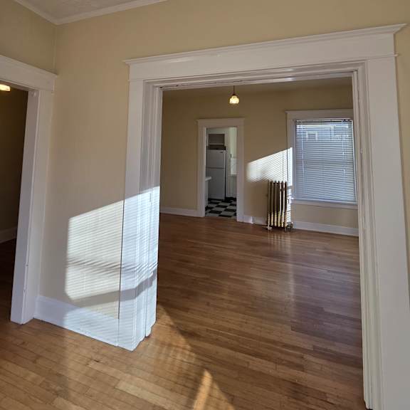 a white framed mirror is on a wooden wall. at casa del rey apartments, portland, or, 97209