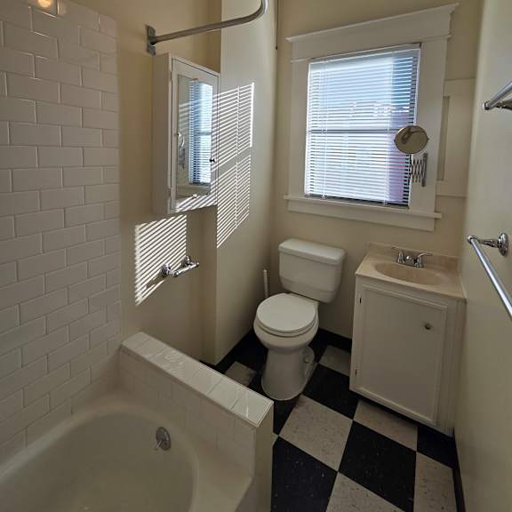 a bathroom with a white tub, sink, and toilet. at casa del rey apartments, portland, 97209