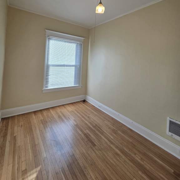 a wooden floor leads up to a window in a room with a white ceiling. at casa del rey apartments, portland, or, 97209