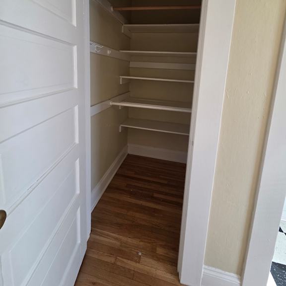 a white door is open to a room with wooden walls. at casa del rey apartments, portland, oregon