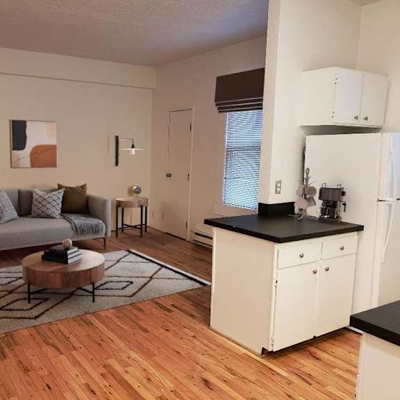 an open living room and kitchen with a wood floor