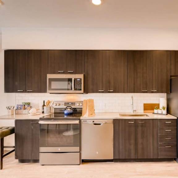 a modern kitchen with a stainless steel refrigerator, oven, and microwave.at holm at sellwood, oregon, 97202