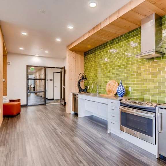 a kitchen with a green tiled wall and white appliances.at holm at sellwood, oregon