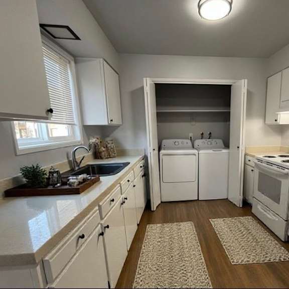 a white kitchen with a sink, stove, and refrigerator.