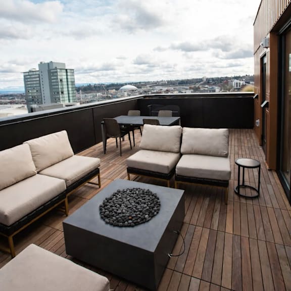 a balcony with a table and chairs overlooking a cityscape.
