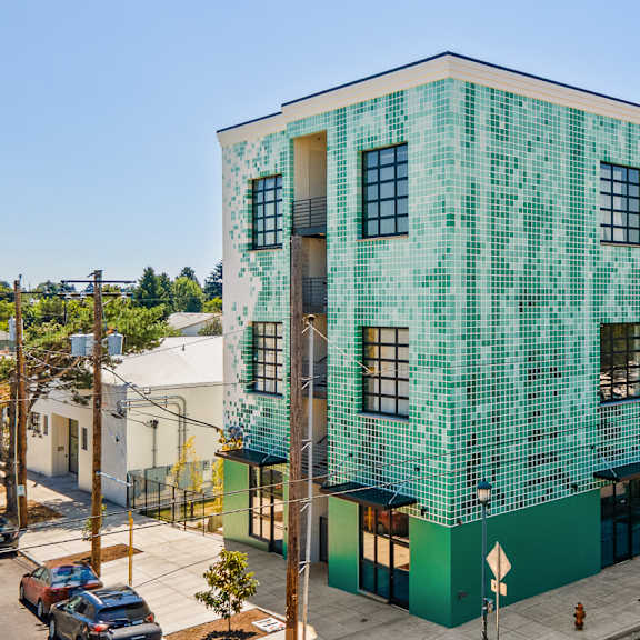 a green building with a white building in the background.