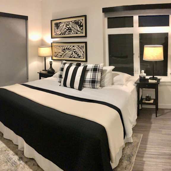a bedroom with a large bed and two lamps.
