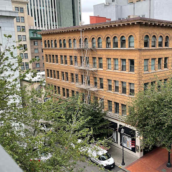 a large building with a red brick facade is surrounded by trees and other buildings.