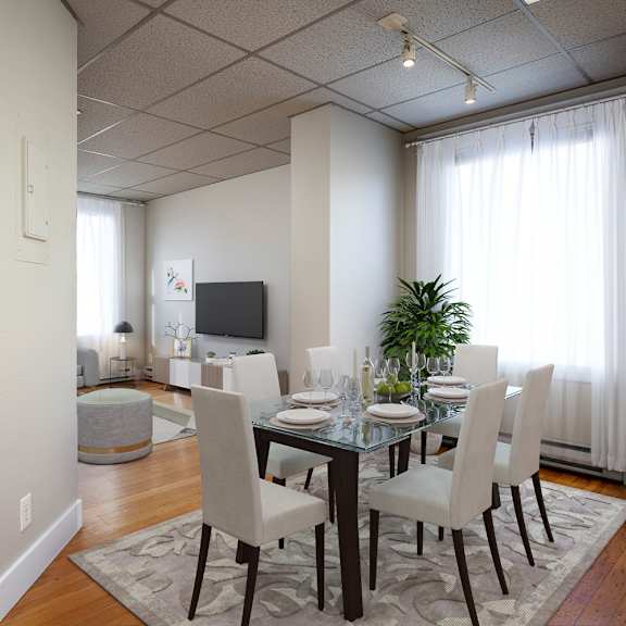 a dining room with a glass table and chairs.
