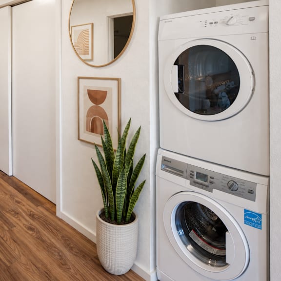 a washing machine is placed in a room with wooden flooring.