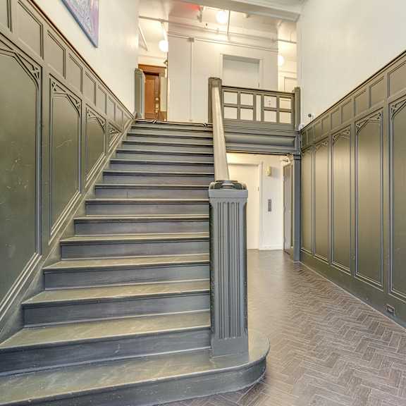 a staircase with a metal railing and steps leading to a doorway at clay & tiffany, portland, 97201