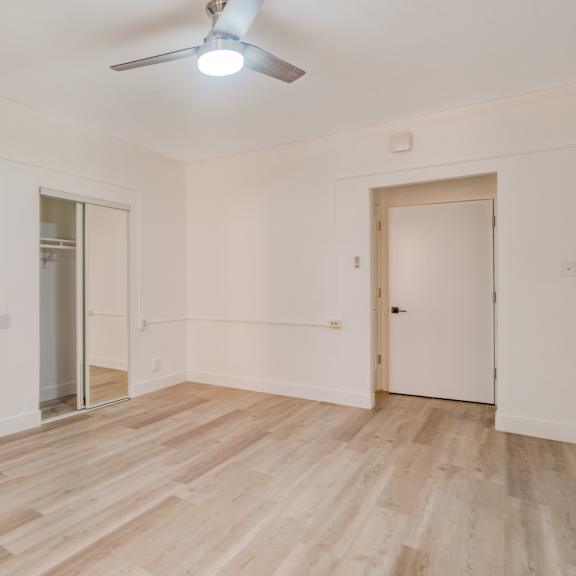 a room with wooden floors and white walls, with a ceiling fan and three doors at clay & tiffany, portland, 97201