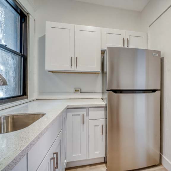 a kitchen with a stainless steel refrigerator and white cabinets at clay & tiffany, portland, 97201