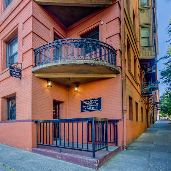 a red building with a balcony and a sign that says at clay & tiffany, portland, 97201